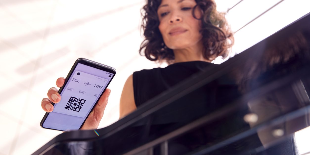 Businesswoman In Airport Departure Lounge Scanning Digital Boarding Pass On Smart Phone Airports Passenger Touchpoint Tracker